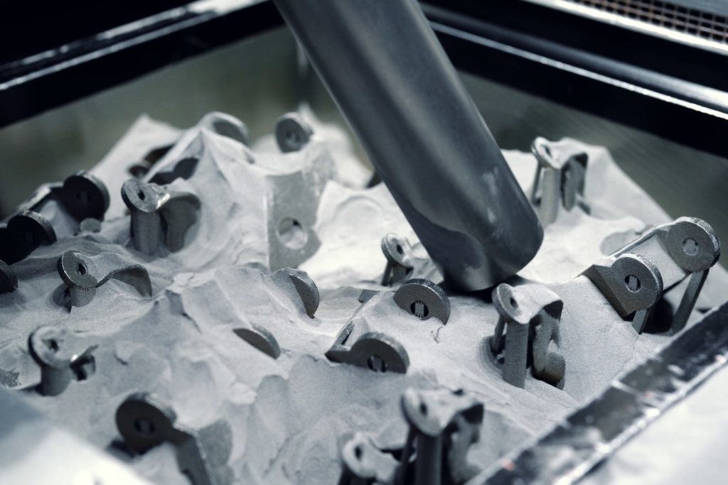 Extraction of unused metal powder after 3D printing with a suction lance. The metal powder is vacuum conveyed into a PowTReX system. There, the metal powder is processed by sieving and can then be used again for the next print job.