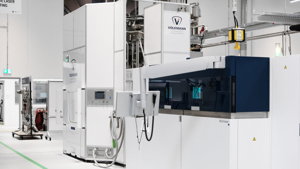 Volkmann centrale poederherwinnings- en opwerkingseenheid (links) naast een TRUMPF TruPrint5000 3D-printer (rechts) op de BMW Group